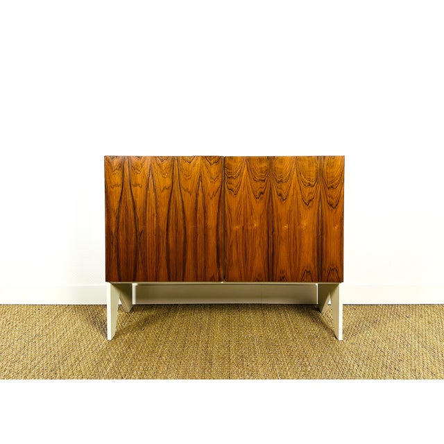 A walnut sideboard dating from the 1960s, featuring two storage doors with shelves. walnut doors, white painted frame....