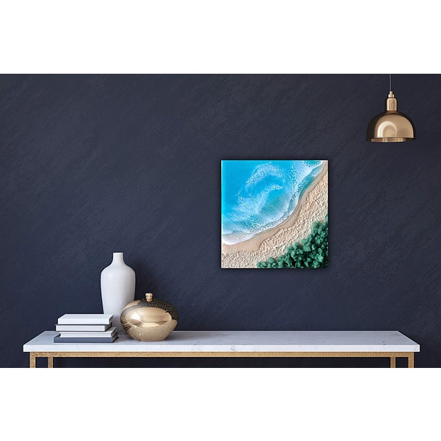 This mixed media piece captures a serene beach scene, where the gentle waves meet the textured shoreline. The vibrant...