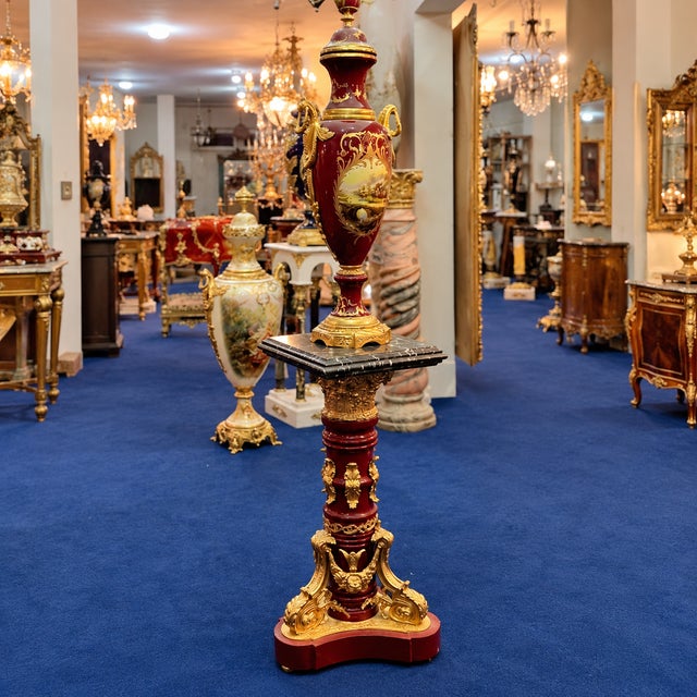Make a magnificent statement with this exceptional decorative ensemble, featuring an elegant burgundy porcelain vase...