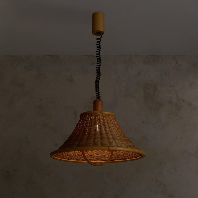 Woven rattan defines the body of this 1970s French pendant, shaped within a bentwood frame that brings structure to an...