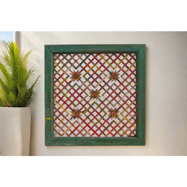 A large green painted window panel with carved star details and a see-through cross weave design. Originally lattice...