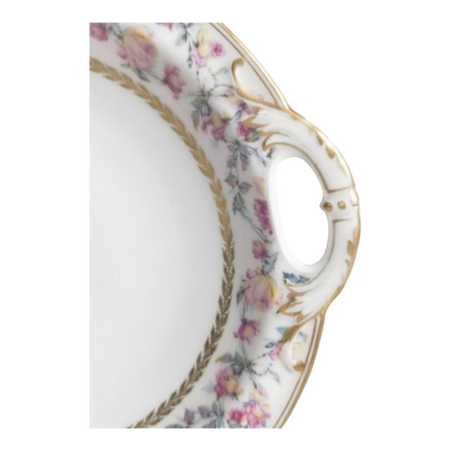 An exquisite antique Haviland & Co. Limoges serving plate adorned with delicate climbing roses and sprays of soft pink,...