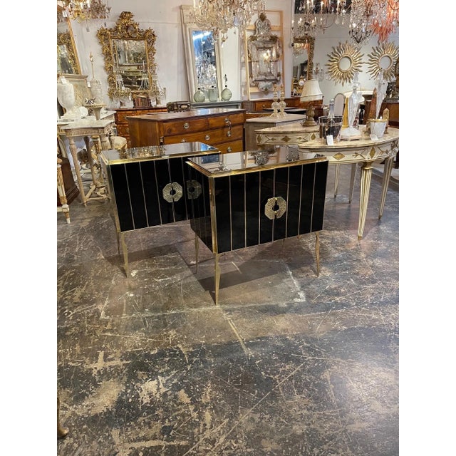 Very sleek pair of Murano Glass and brass side tables. Creates an amazing polished look with the glistening black glass...