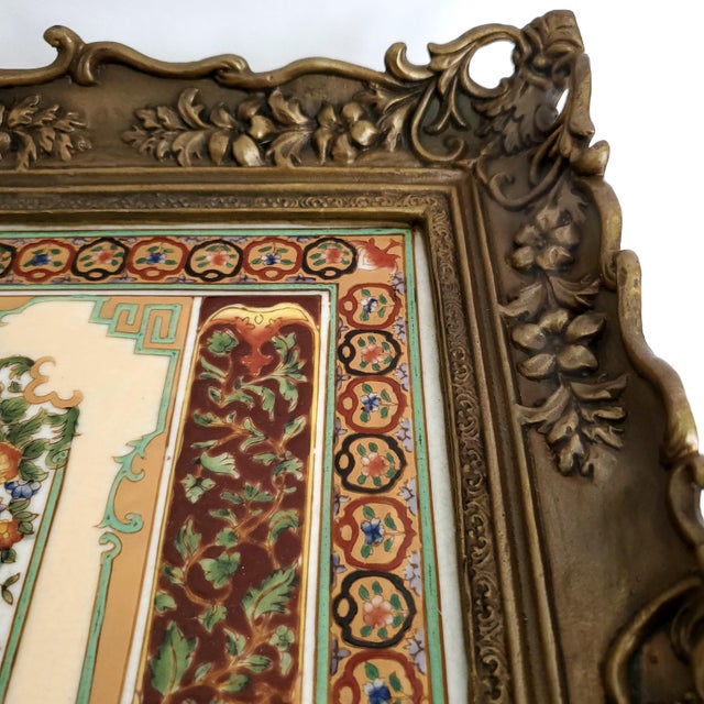 Offering a stunning bronze finish and porcelain handcrafted and hand painted decorative tray by Castilian, circa 1970s....