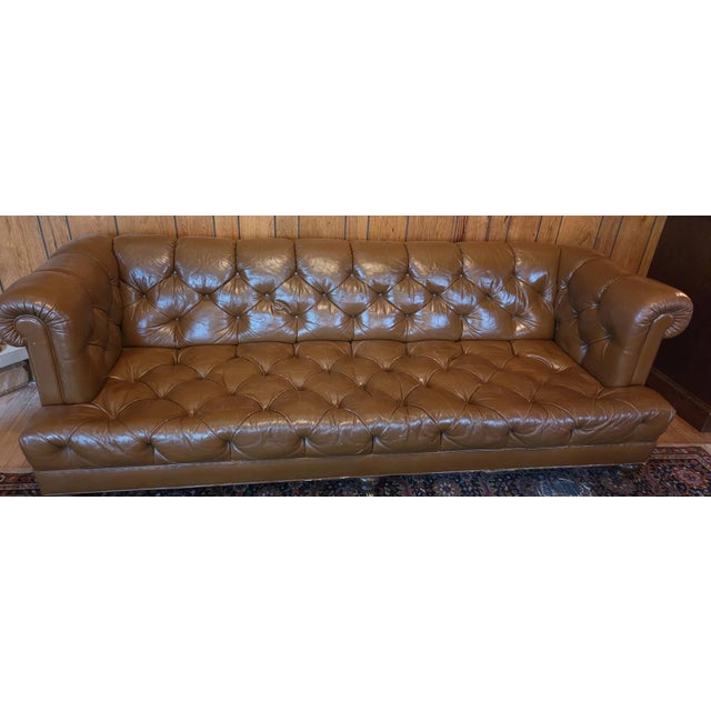 Offered is an iconic tufted brown leather sofa set on brass casters by Cocheo Brother NYC. This piece is all orginal and...