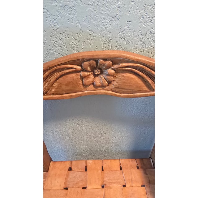 This rustic armchair features a hand-carved floral motif on the backrest and a traditional woven seat.Style: The piece...