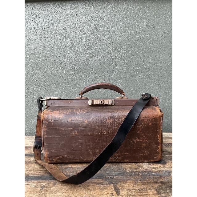 This exceptional vintage doctor’s bag, often referred to as a Gladstone bag, is a masterclass in rugged early 20th-century...