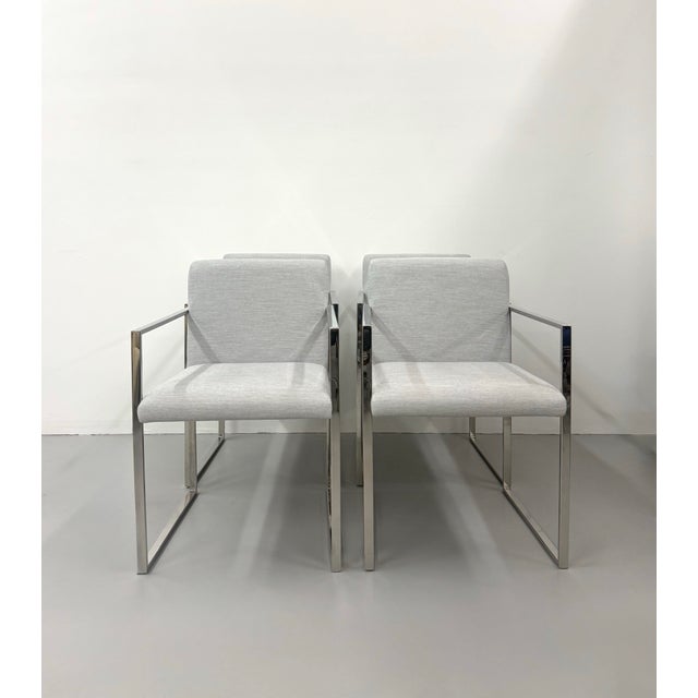 A sleek set of four armchairs by Palecek featuring polished chrome frames with clean, architectural lines. Each chair is...