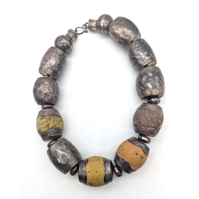 Offered is a chunky artisan-crafted choker statement necklace featuring large, barrel-shaped and round hammered silver-...