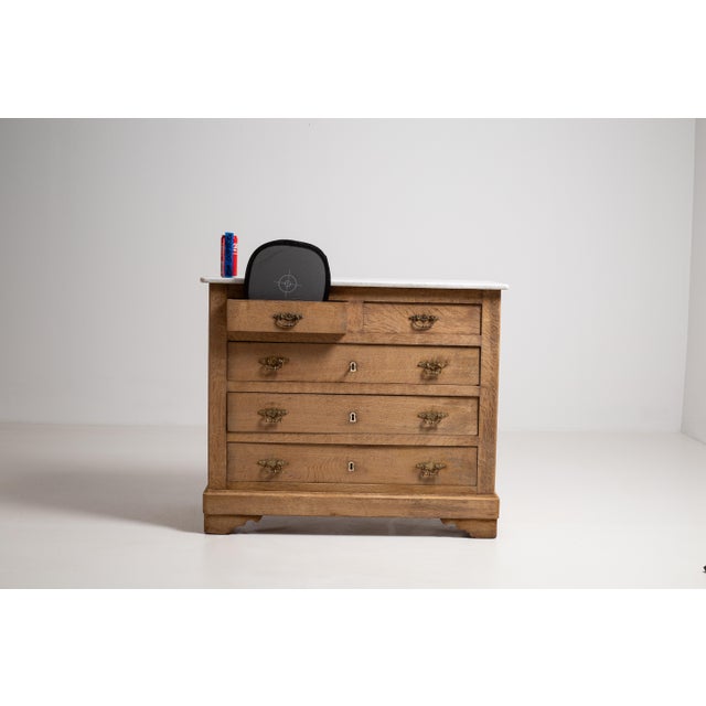 A distinguished example of 19th-century French craftsmanship, this compact chest of drawers is rendered in warm, richly...