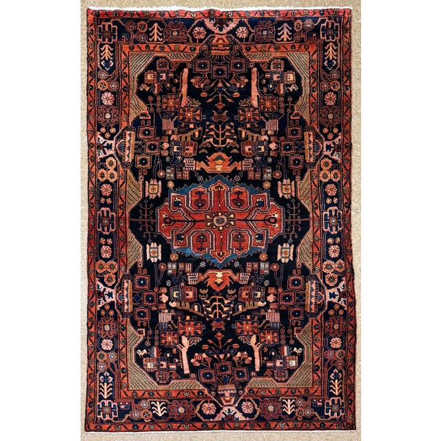 Hand-knotted Nahavand rug from western Iran, featuring a geometric medallion composition set within a deep indigo field....