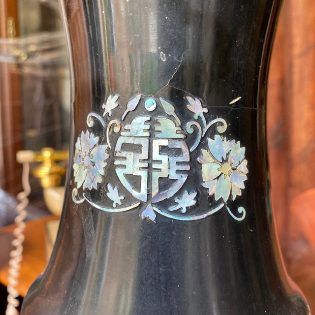 Beautiful tall black vase with mother of pearl details in the eternity symbol and peacock details. Great to display as is....