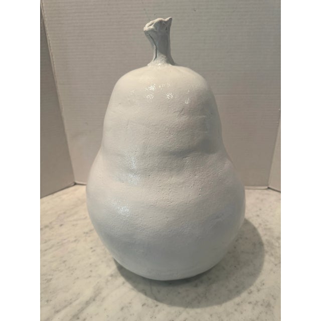 A Terra cotta pear finished in a white gloss paint. Great decor for the kitchen.