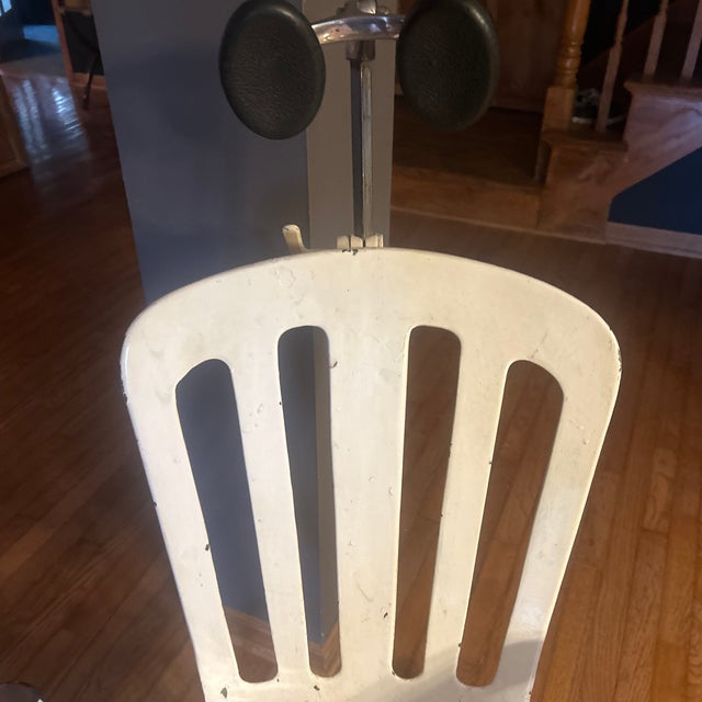 Late 1920s-30s white cast iron dentist chair; chrome arm rests and seat; seat can be raised or lowered; chair reclines;...