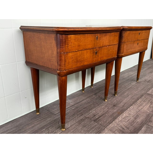 This pair of vintage nightstands, likely dating back to the 1950s, is made of wood veneer with glass tops. Each features...