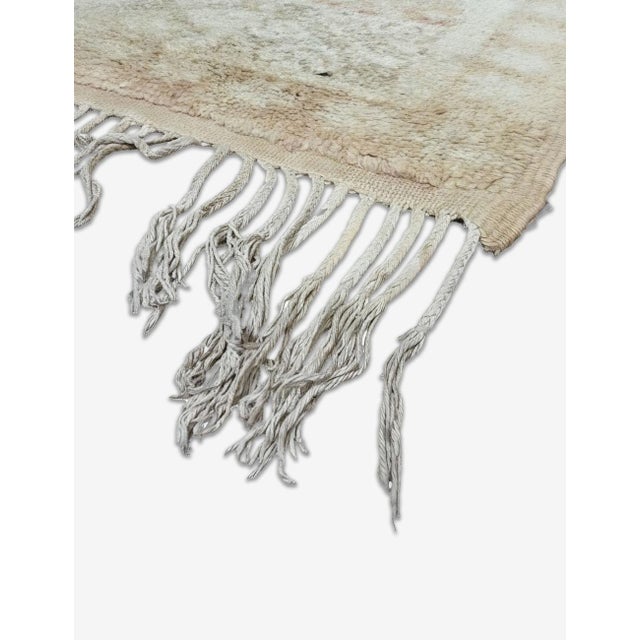 Vintage Moroccan Rug | Handwoven Wool Rug with Faded Ivory Field and Cobalt Accent Medallion This atmospheric vintage rug...