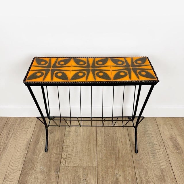 We instantly fell in love with this magazine rack with its seventies diva vibe. The orange and black top is pure...