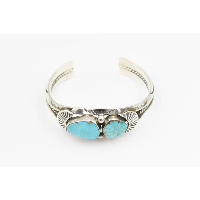 A striking Southwestern cuff bracelet attributed to Navajo silversmith Delbert Chatter, featuring two vibrant blue...