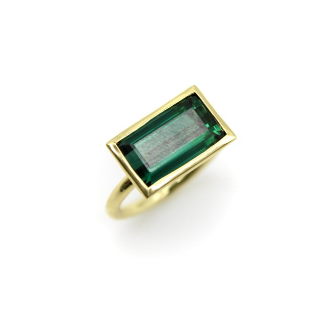 This bezel set tourmaline ring features a striking indicolite blue-green tourmaline. The 6.8 carat stone is a modified...