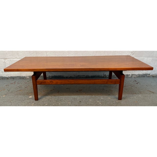 Bring timeless Mid-Century Modern style into your home with this elegant walnut coffee table designed by renowned Danish-...