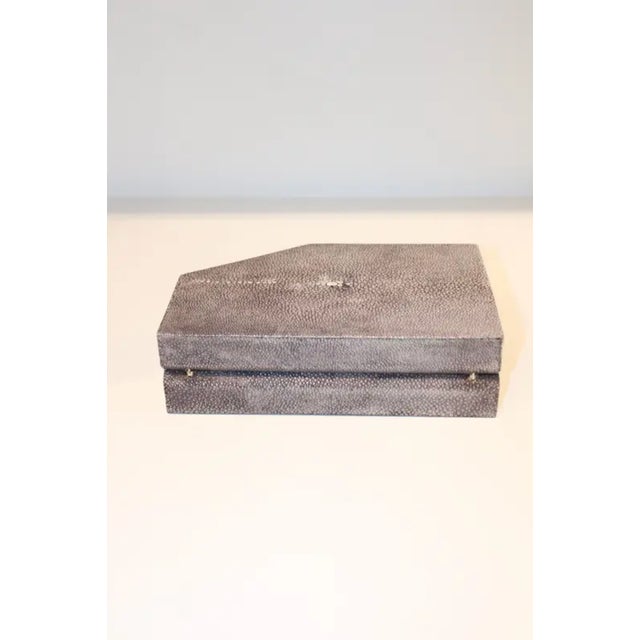 This elegant box is made of shagreen with beautiful decor on the front. The box is hinged with a black microsuede...