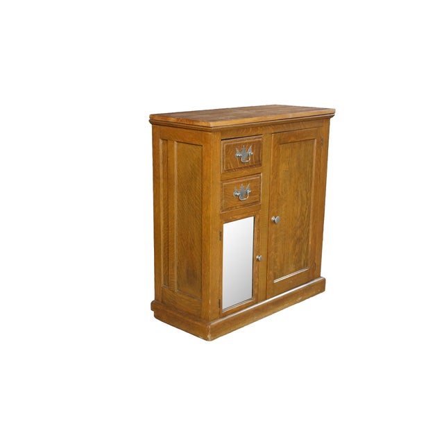 This exceptional antique Golden Oak era cabinet (circa 1890–1910) is expertly crafted from solid wood, highlighting a...
