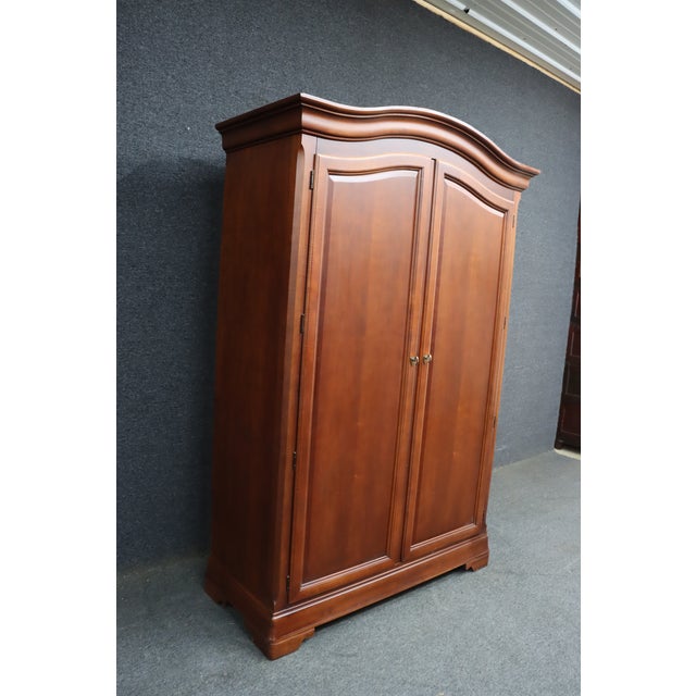 Thomasville Impressions cherry armoire featuring softly arched crown molding, paneled double doors, molded base, and a...