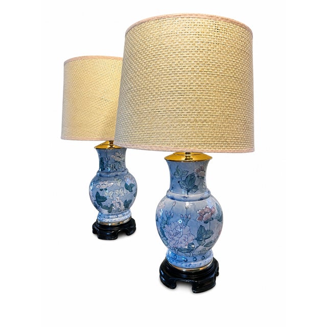 An elegant matching pair of vintage Chinoiserie-style porcelain table lamps dating to the 1980s. Each lamp features a...
