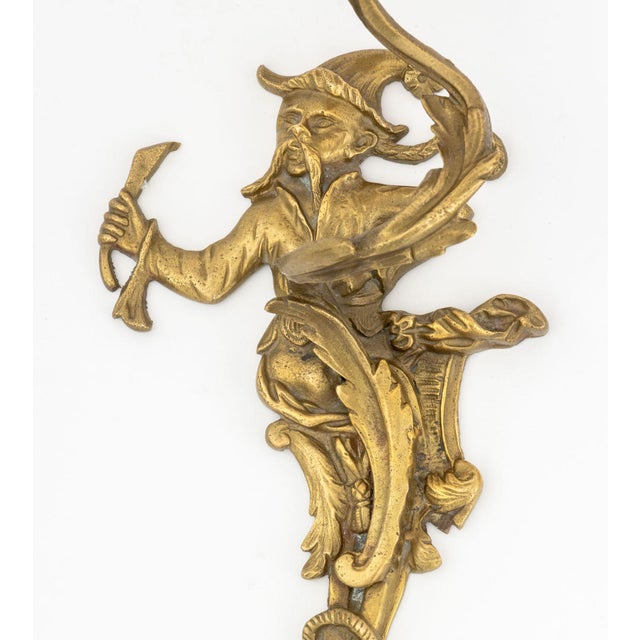 Associated Pair of Louis XV Style Chinoiserie Brass Candlestick Wall Sconces, each depicting male figures upholding a...