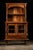 This wooden hutch features two open shelves on top, two glass-encased shelves below, and a single drawer on bottom. The...