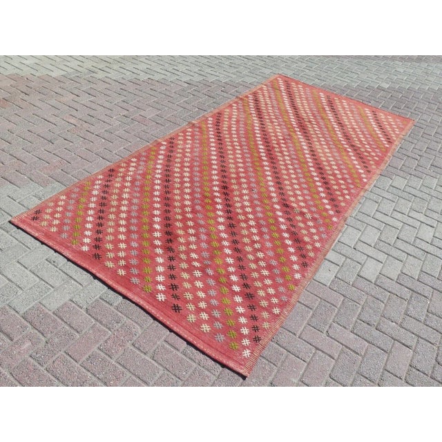 This beautiful, traditional vintage, flatweaved Turkish kilim rug is approximately 60 years old. It is handmade of very...