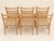 A set of six dining chairs that gracefully embody the elegance of 1960s scandinavian design. their solid wood frames—oak...