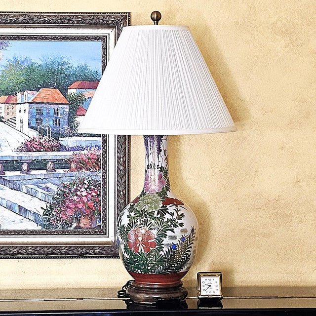 Vintage American-made Chinoiserie porcelain table lamp featuring a hand-painted floral garden design on a creamy white...