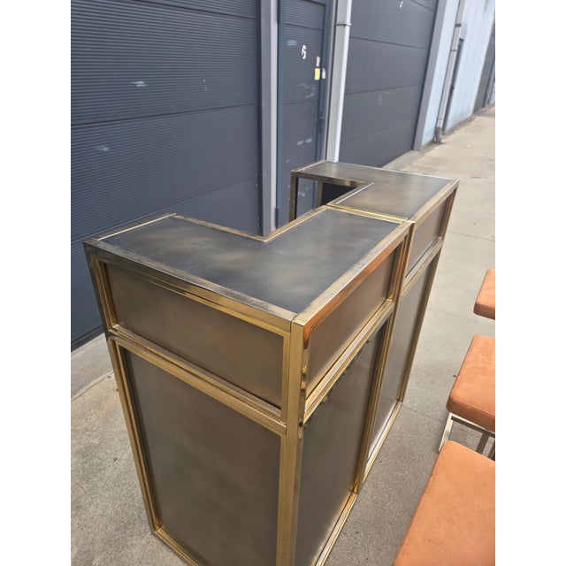 Striking vintage bar set featuring a sculptural brass-finished metal frame, dark inset panels and three matching bar...