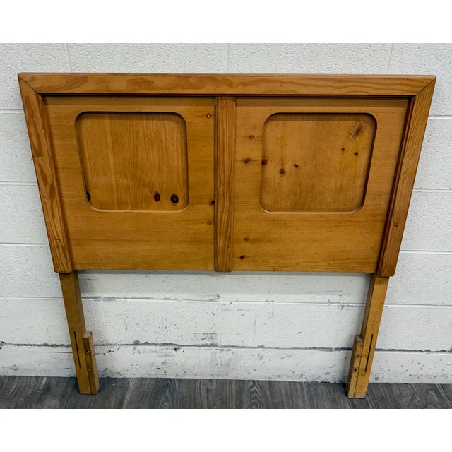 This is a vintage 1970s rustic-modern headboard featuring warm knotty pine veneers, rounded recessed panels, linear...