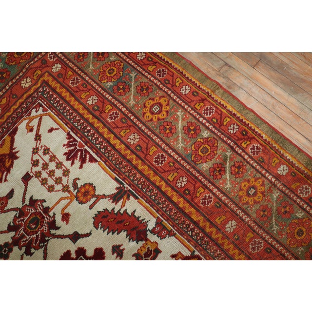 A late 19th century Turkish Oushak with an all over geometric design on an ivory color field. The border is a dark forest...