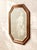 A handsome vintage wall mirror featuring an angular octagonal silhouette framed in warm walnut-toned wood. The beveled...
