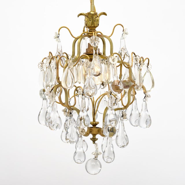 Antique brass and crystal chandelier from France. This piece has a brass structure with lovely curving forms. The...