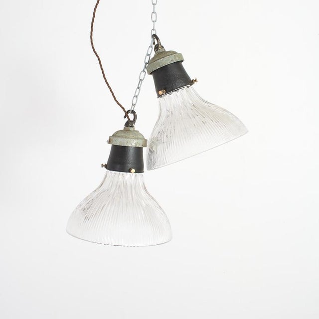 A pair of antique prismatic glass stiletto holophane pendant light shades. The light have retained their original...
