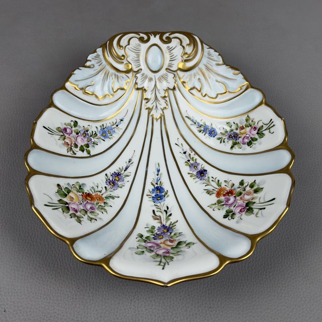 A refined French-made decorative object, an expression of classic Limoges elegance. This centerpiece (or serving dish) is...