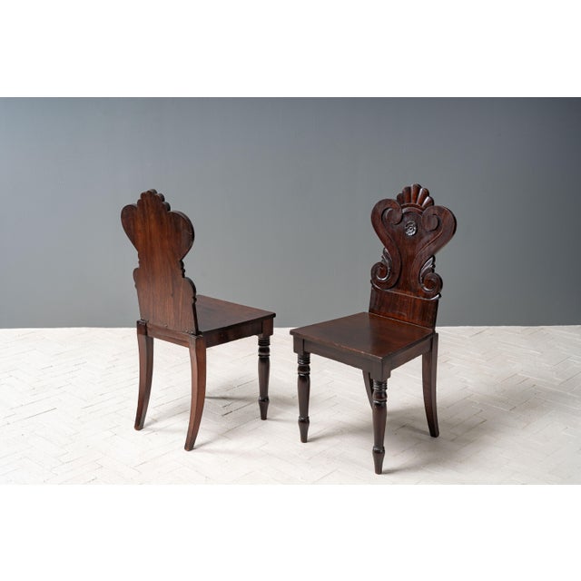 England, ca. early 19th century. A fine pair of antique Regency mahogany hall chairs after the style of Gillows. Expertly...