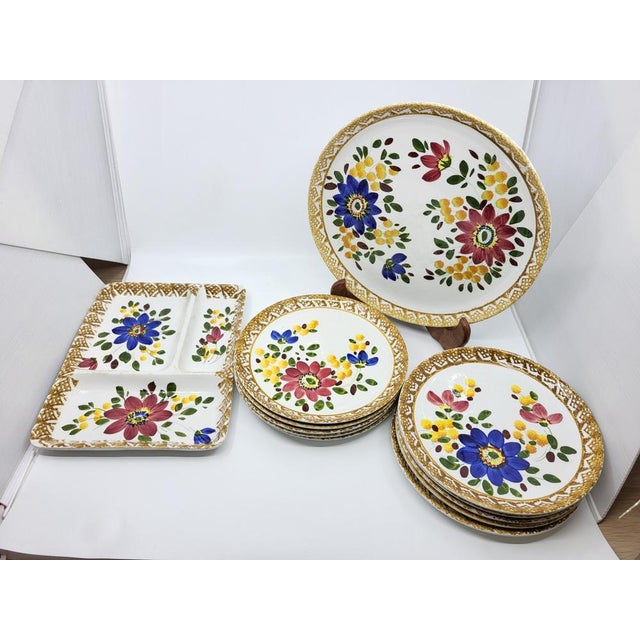 This magnificent 1970s dinner service, featuring a multicolored floral design, consists of 10 dinner plates and two...