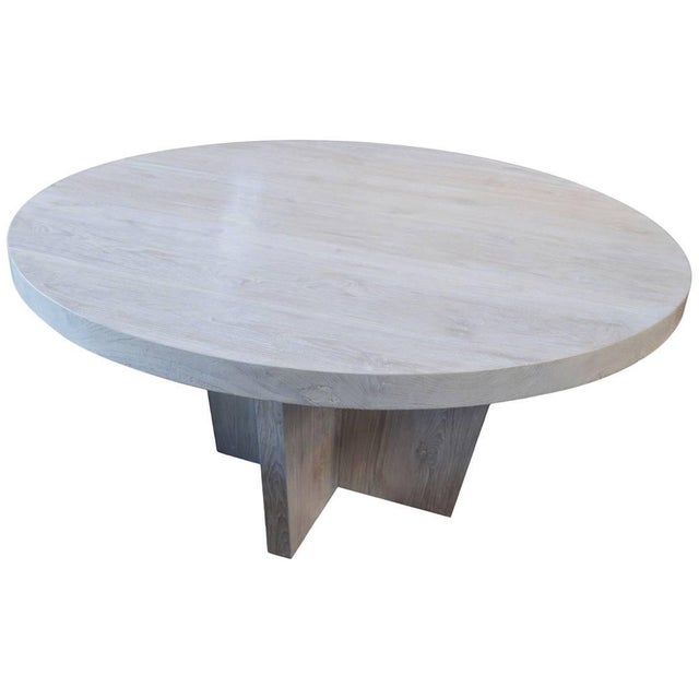 Impressive reclaimed teak dining table or entrance table with a light white wash finish. Shown on a modern cross base. The...
