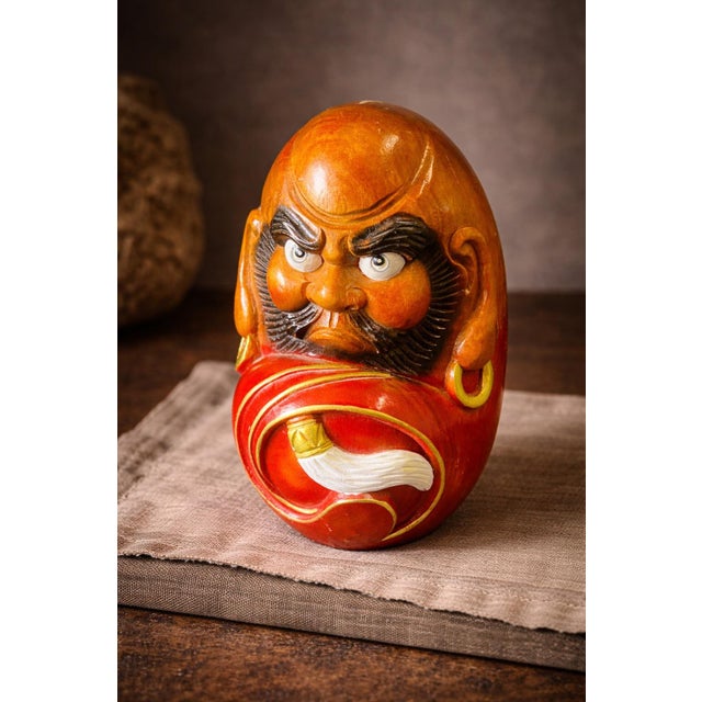 Hand-Carved Japanese Daruma Figure – Bodhidharma Symbol of Resilience A striking hand-carved wooden Daruma figure...