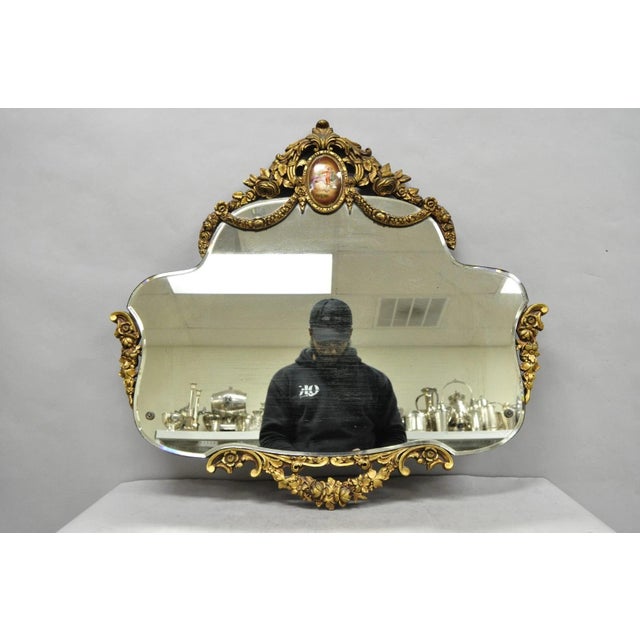 Antique French Rococo Victorian Gold Gilt Wood Frame Boudoir Wall Mirror with Porcelain Cameo to Crest. Circa Early 20th...
