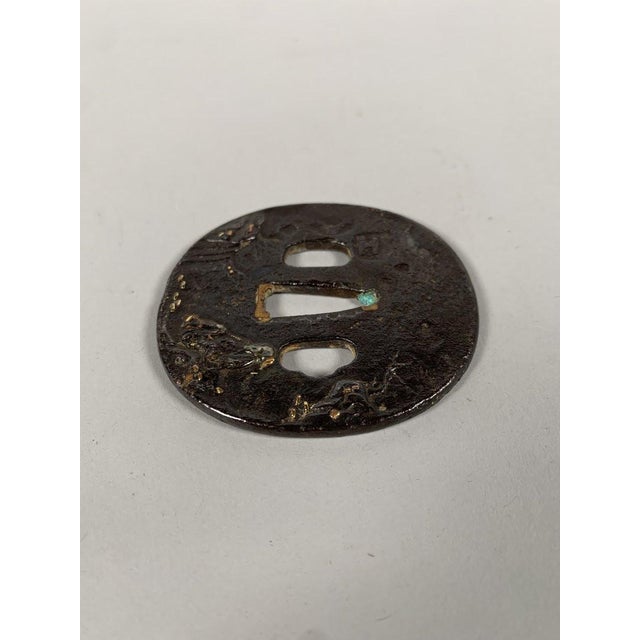 Tsuba Maru-Gata, Edo period (1603-1868), wrought iron inlaid with copper, silver, and gold. Depicts an old man seated on a...
