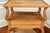 An antique French Provincial two-tier side or end table in a warm honey-toned fruitwood with a galleried top, lower shelf,...