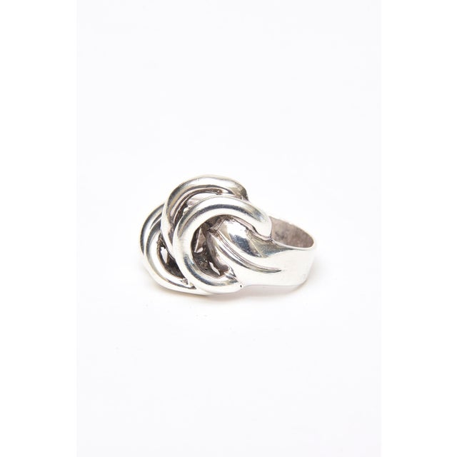 This lovely vintage 1960's sterling silver sculptural ring has interlocking circles in a raised pattern. The band at the...