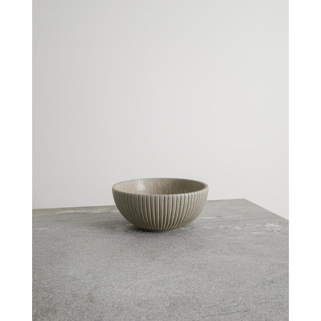 A rare and iconic light grey Danish mid century stoneware bowl with decorative and vertical grooves by Arne Bang produced...