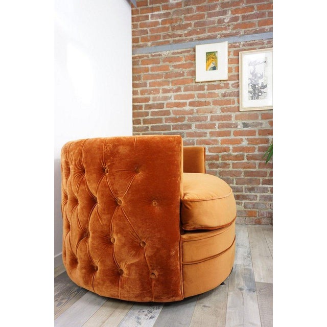 Large swivel armchair upholstered in ultra-soft orange velvet